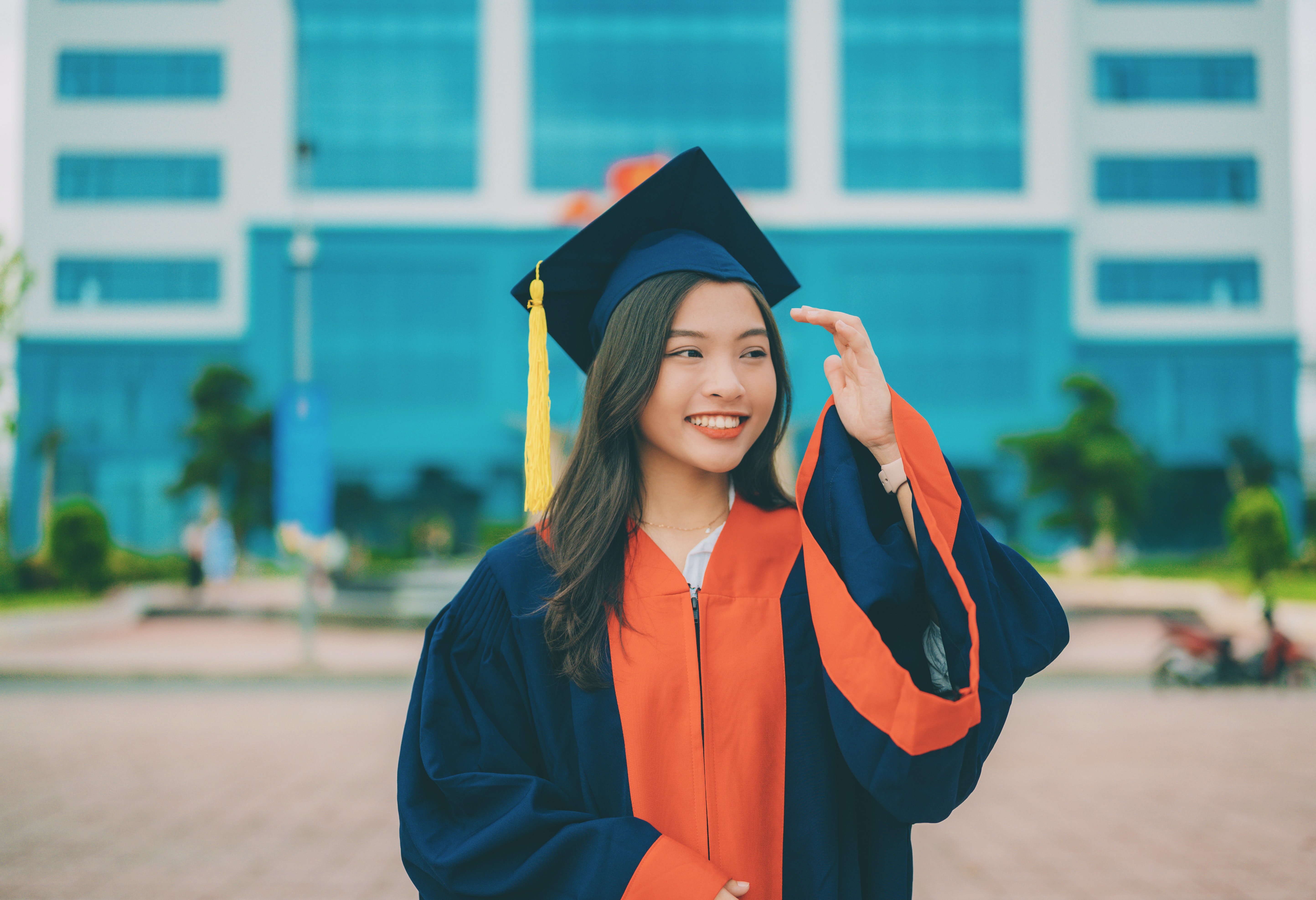 Graduate with mortar board and gown smiling celebrating graduation